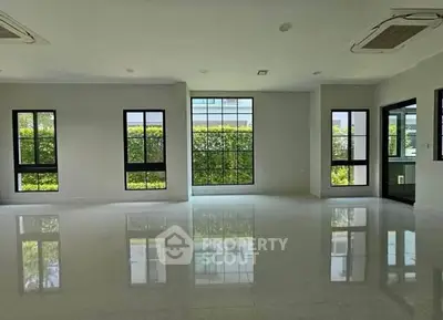 Spacious modern living room with large windows and glossy floors