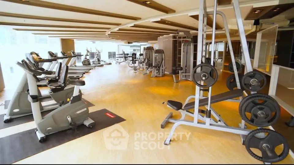 Spacious modern gym with state-of-the-art fitness equipment and bright lighting.
