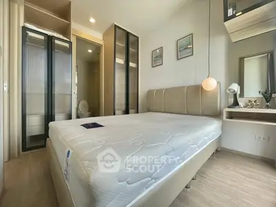 Modern bedroom with stylish decor and ample natural light, featuring a comfortable bed and sleek storage solutions.