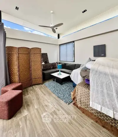 Modern living room with stylish decor and natural light, featuring a cozy sectional sofa and wooden flooring.