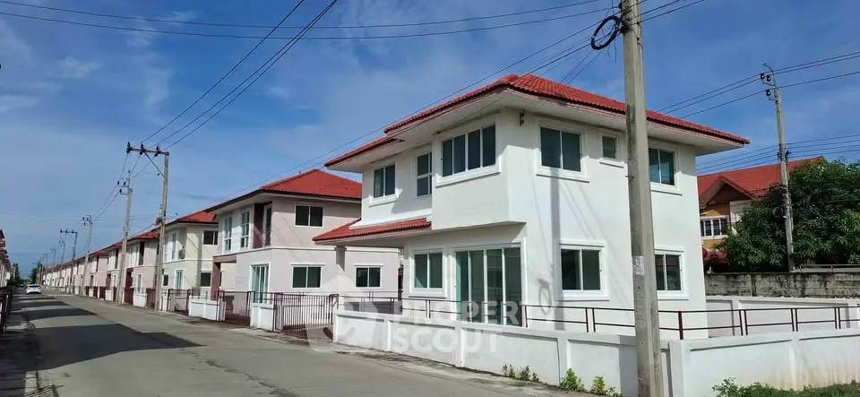 Modern two-story houses with red roofs in a suburban neighborhood, showcasing clean lines and spacious layouts.