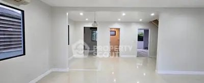 Spacious open-plan living area with modern lighting and glossy floors