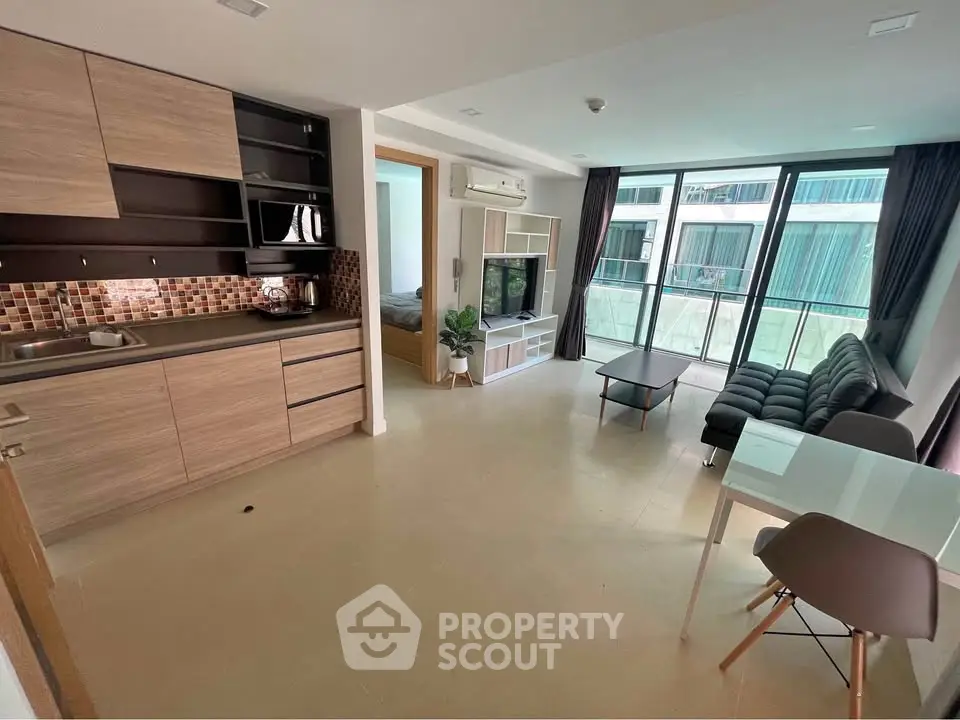 Modern open-plan living room with kitchen and balcony view in stylish apartment
