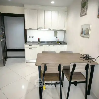 Modern kitchen with sleek cabinets and dining table in cozy apartment