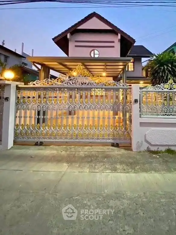 Elegant house exterior with ornate gate and warm lighting at dusk