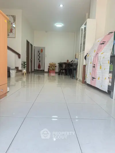 Spacious interior with glossy tiled flooring and modern decor, ideal for versatile living space.