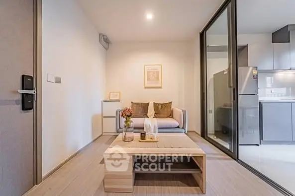 Modern living room with cozy sofa and open kitchen layout, perfect for urban living.