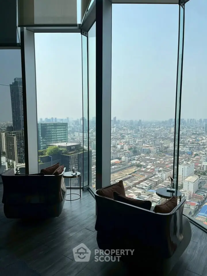Luxurious high-rise apartment with stunning panoramic city view from floor-to-ceiling windows.