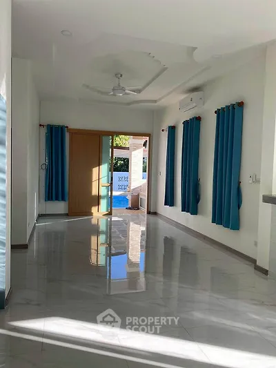 Spacious living room with modern design and large windows offering natural light.