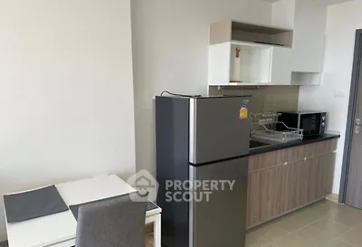 Modern kitchen with sleek appliances and dining area in contemporary apartment.