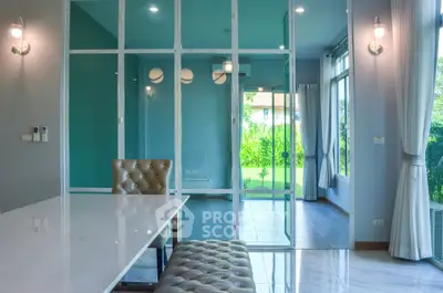 Modern interior with glass partition, elegant lighting, and garden view.