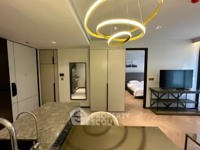 Modern open-plan kitchen and living area with stylish lighting and sleek furnishings.