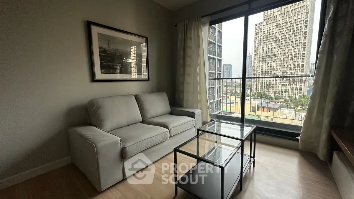 Modern living room with city view, featuring a cozy sofa and glass coffee table.