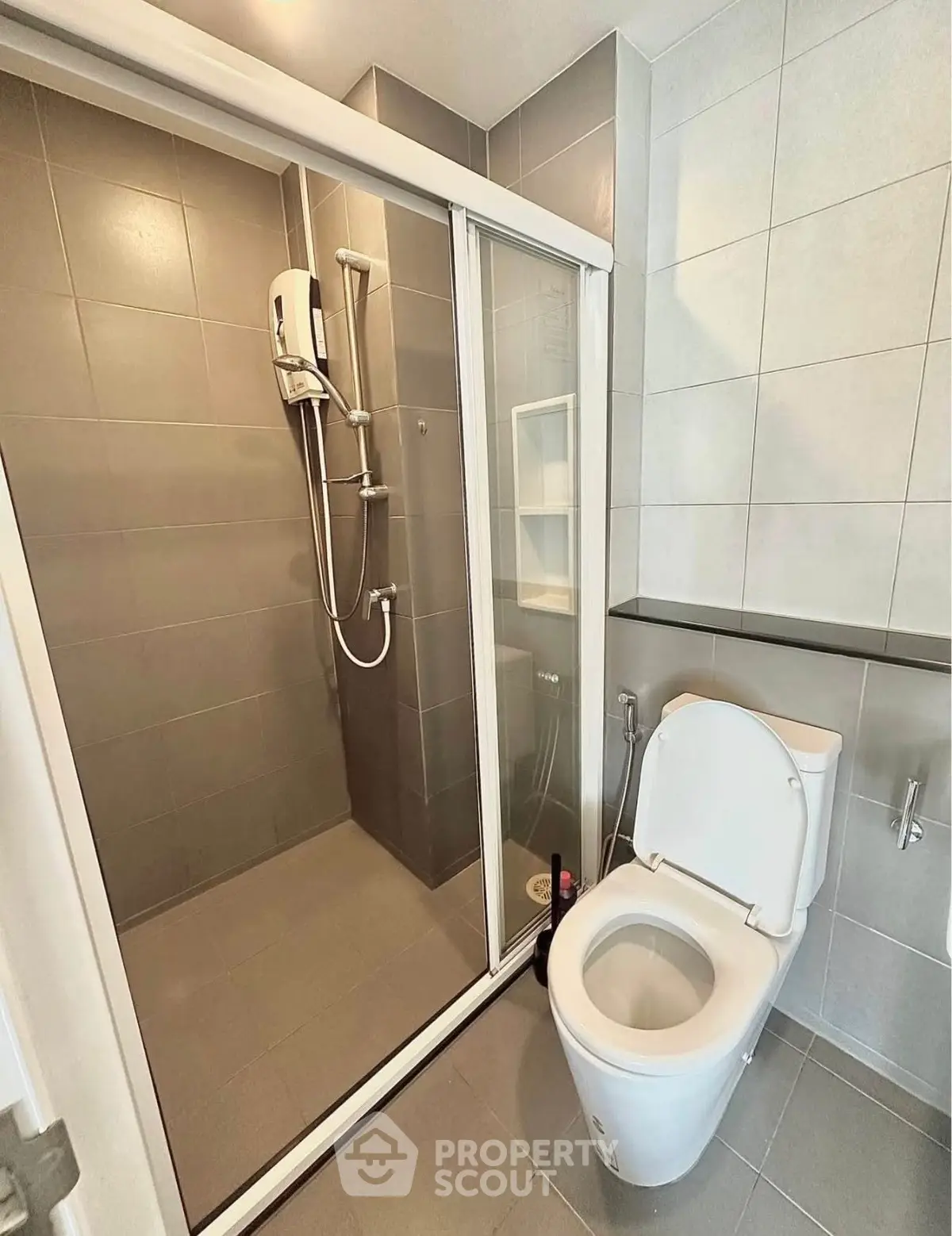Modern bathroom with sleek shower and toilet in minimalist design.
