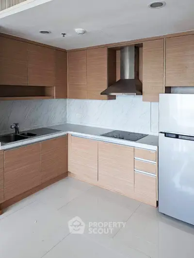 Modern kitchen with sleek cabinetry and stainless steel appliances in a stylish apartment.
