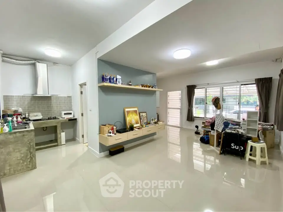Spacious open-plan living room with modern kitchen and ample natural light.