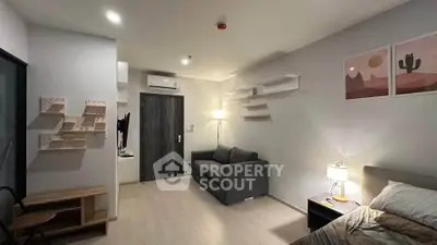 Modern living room with stylish decor and cozy lighting, featuring a comfortable sofa and wall-mounted shelves.
