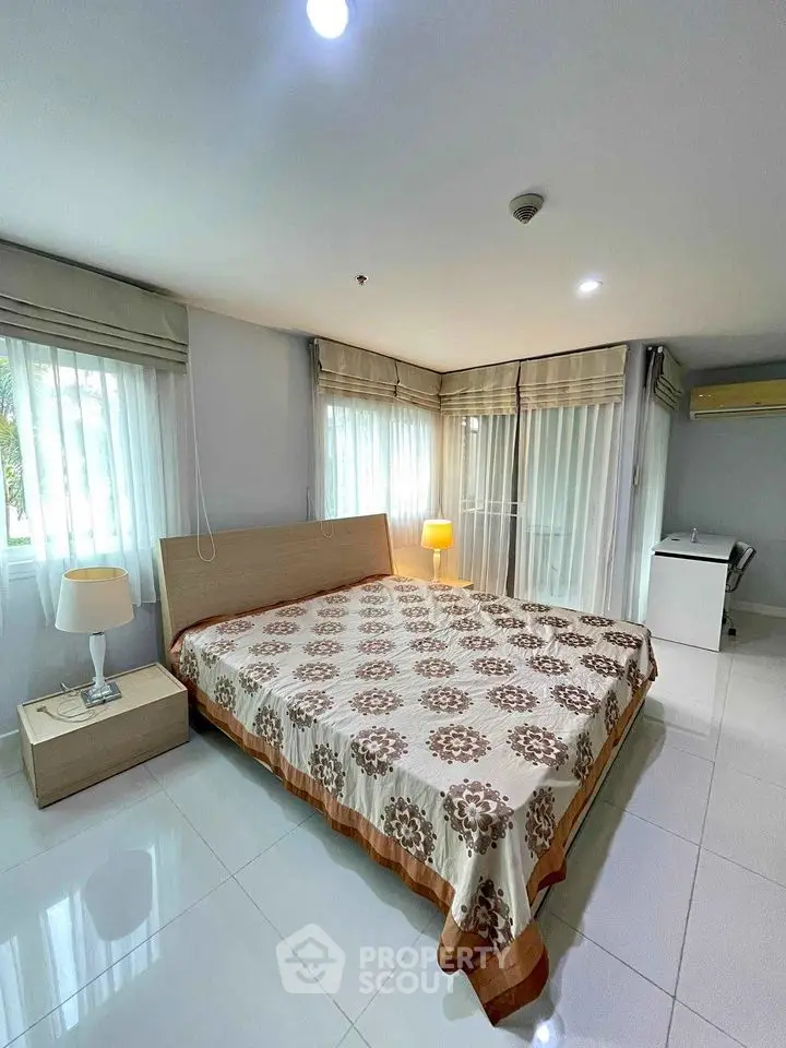 Spacious bedroom with large windows and modern decor for sale