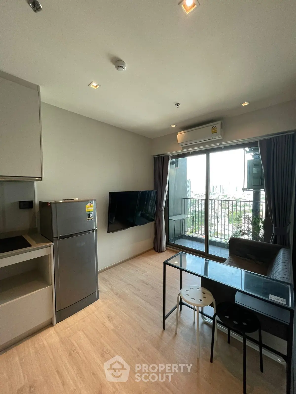 Modern living room with balcony view, sleek furniture, and natural light in a stylish apartment.