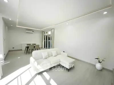 Spacious modern living room with sleek white decor and abundant natural light