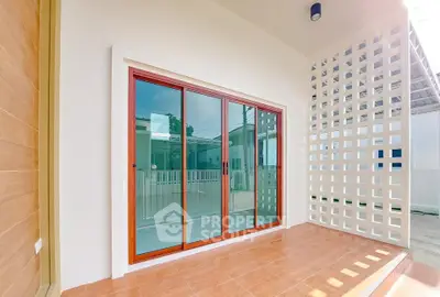 Modern balcony with sliding glass doors and stylish lattice wall design.