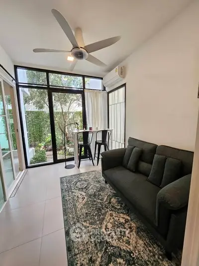 Chic living room with modern decor, large windows, and garden view, perfect for relaxation and entertaining.
