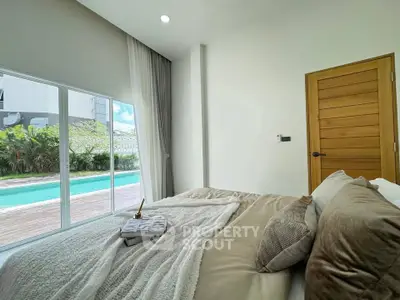 Luxurious bedroom with pool view and elegant decor, perfect for relaxation and comfort.
