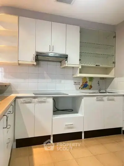 Modern kitchen with sleek white cabinets and glass shelves, perfect for culinary enthusiasts.