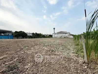Expansive plot of land with potential for development, featuring clear skies and surrounding greenery.