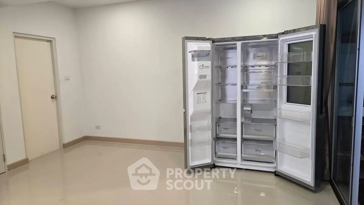 Spacious room with modern refrigerator and glossy tiled floor