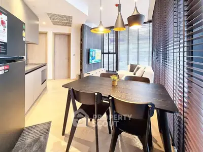Modern open-plan living and dining area with sleek kitchen and stylish lighting.
