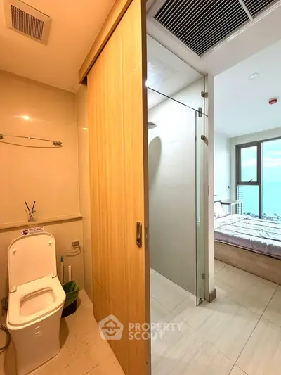 Modern apartment with ensuite bathroom and cozy bedroom, featuring sleek design and natural lighting.