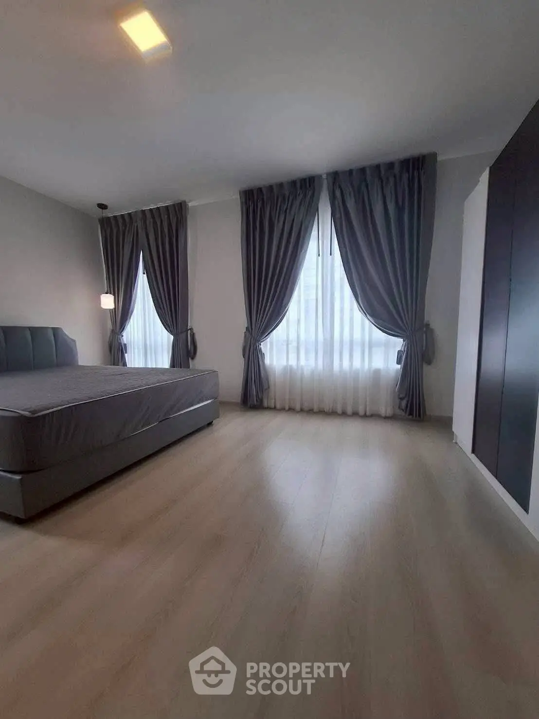 Spacious bedroom with elegant curtains and modern design
