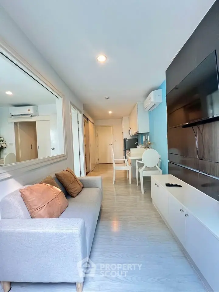 Modern living room with sleek design, featuring a cozy sofa, wall-mounted TV, and stylish dining area.
