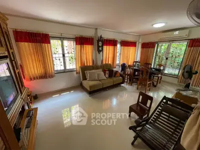 Spacious living room with large windows and elegant furnishings, perfect for family gatherings.
