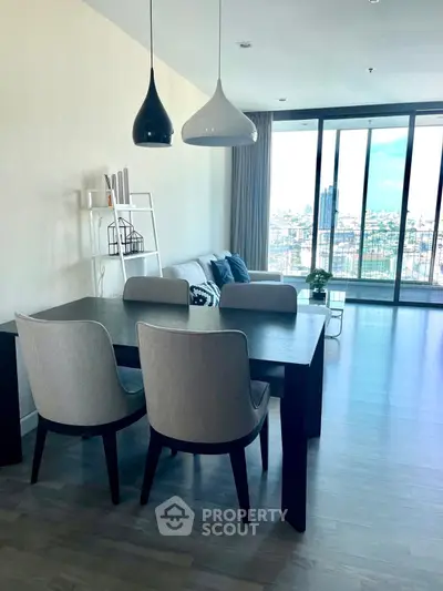 Modern living room with stylish dining area and city view balcony.