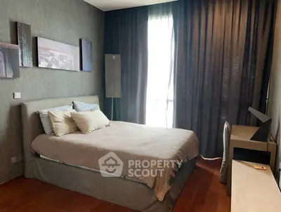 Modern bedroom with elegant decor and natural light, featuring a comfortable bed and stylish furnishings.