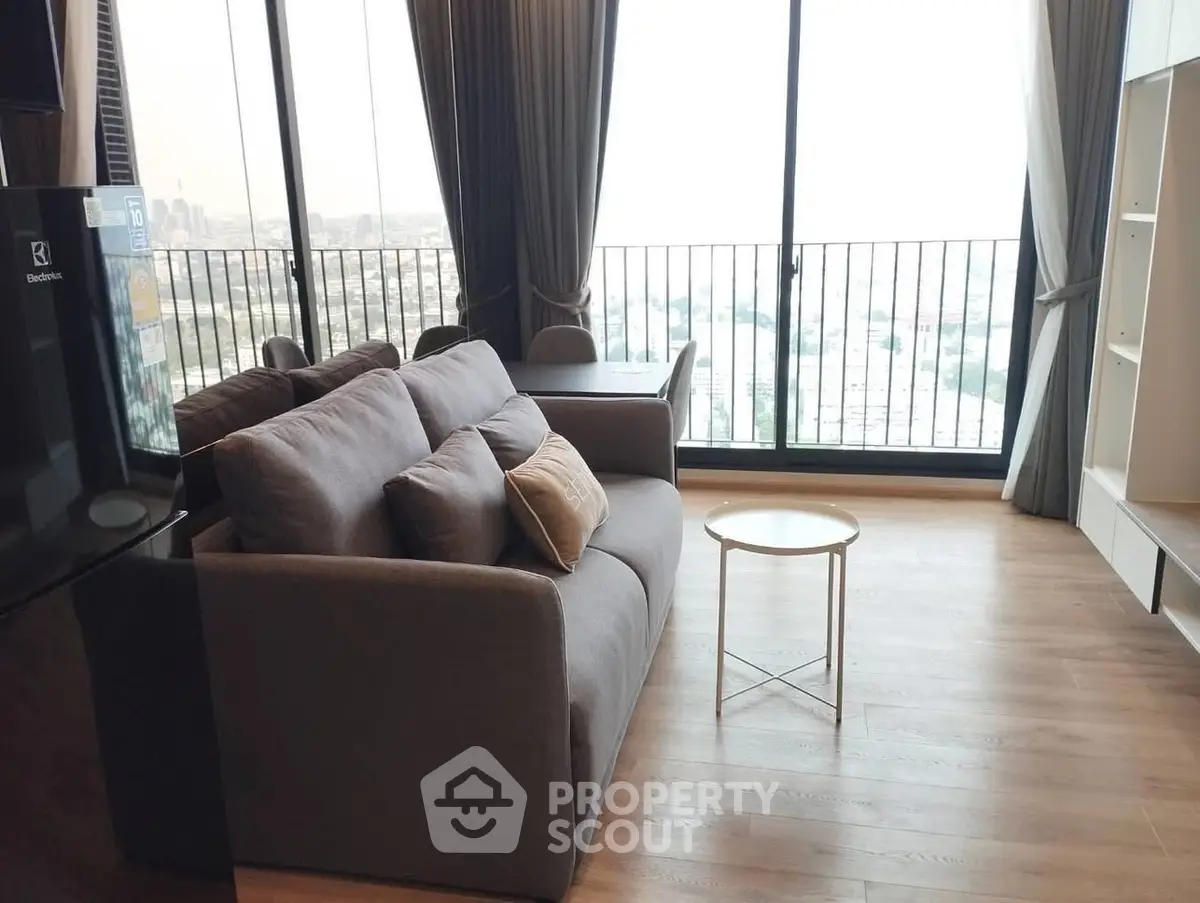 Modern living room with panoramic city view and cozy seating area.