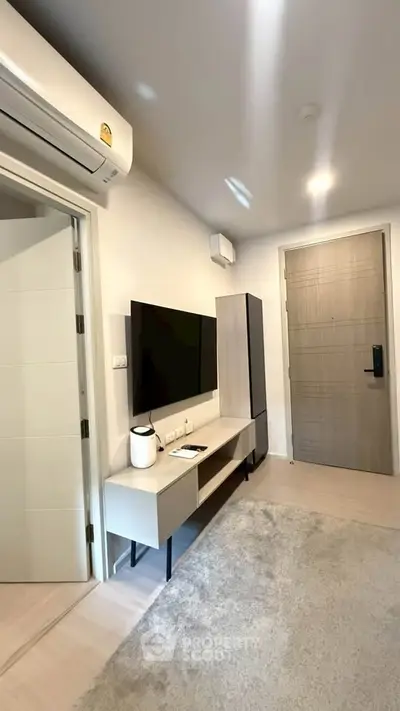 Modern living room with sleek TV unit and air conditioning in a stylish apartment.