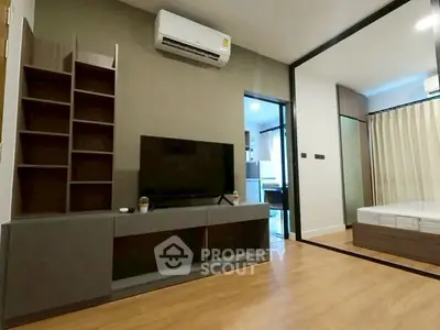 Modern living room with sleek furniture and mirrored wall in a stylish apartment.