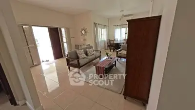 Spacious living room with elegant wooden furniture and natural light, perfect for relaxation and entertaining.