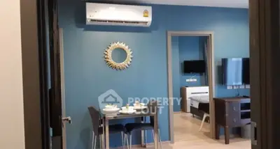 Modern living room with blue accent wall, air conditioning, and stylish dining area.