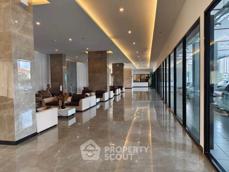 Luxurious modern building lobby with sleek marble floors and elegant seating area.