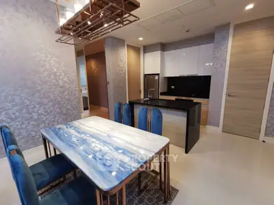 Luxurious modern kitchen with elegant dining area and stylish blue chairs
