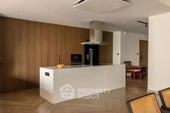 Modern kitchen with sleek island and wooden cabinetry in luxury apartment