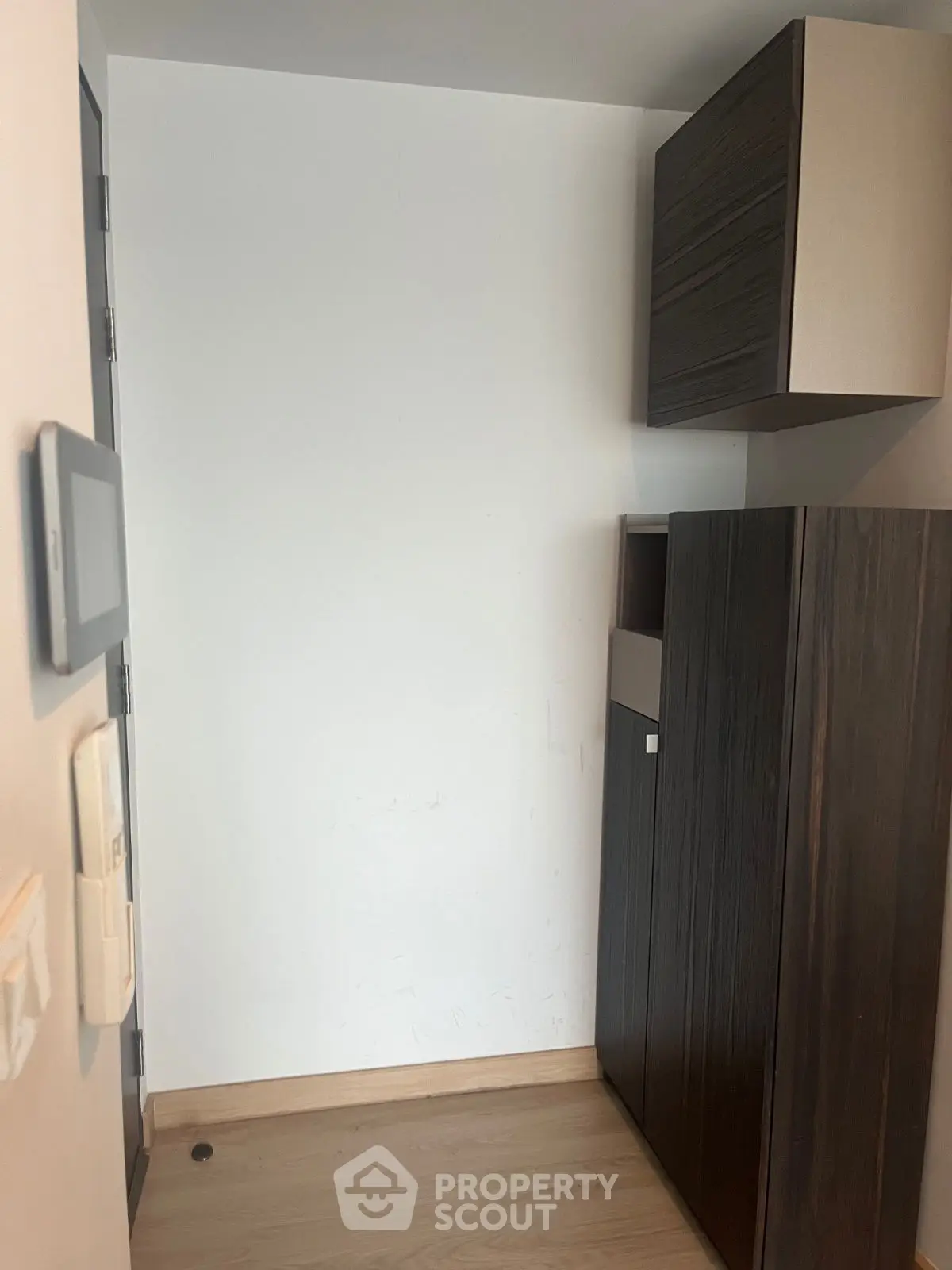 Compact storage area with modern cabinets and wooden flooring in a minimalist design.