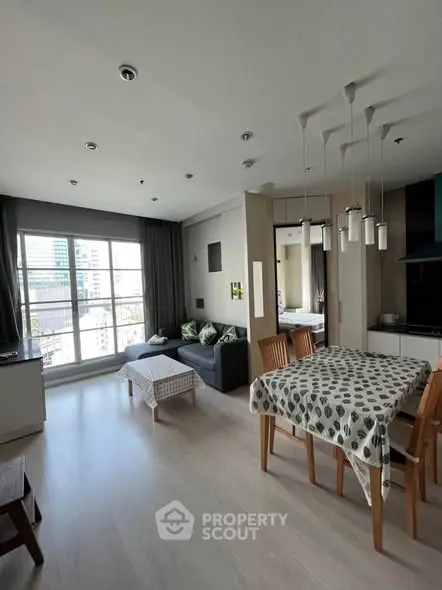 Spacious modern living room with dining area and large windows in a stylish apartment.