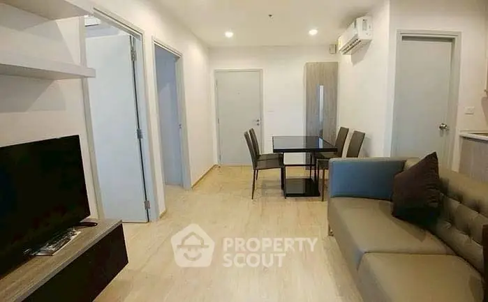 Modern living room with dining area, featuring sleek furniture and neutral tones.