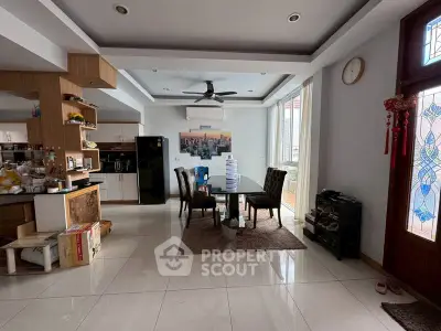 Spacious open-plan living and dining area with modern kitchen and large windows.