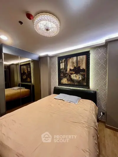Luxurious bedroom with elegant decor and mirrored wardrobe in modern apartment.